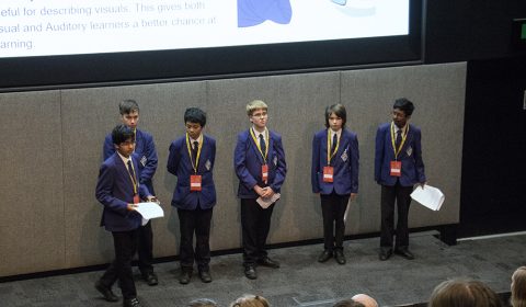 a group of people standing in front of a television