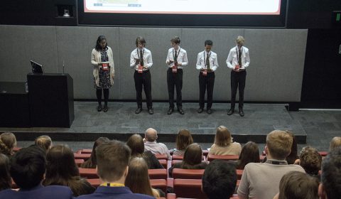 a group of people standing in front of a television