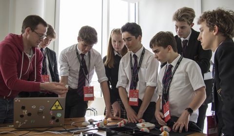 a group of people standing in front of a computer