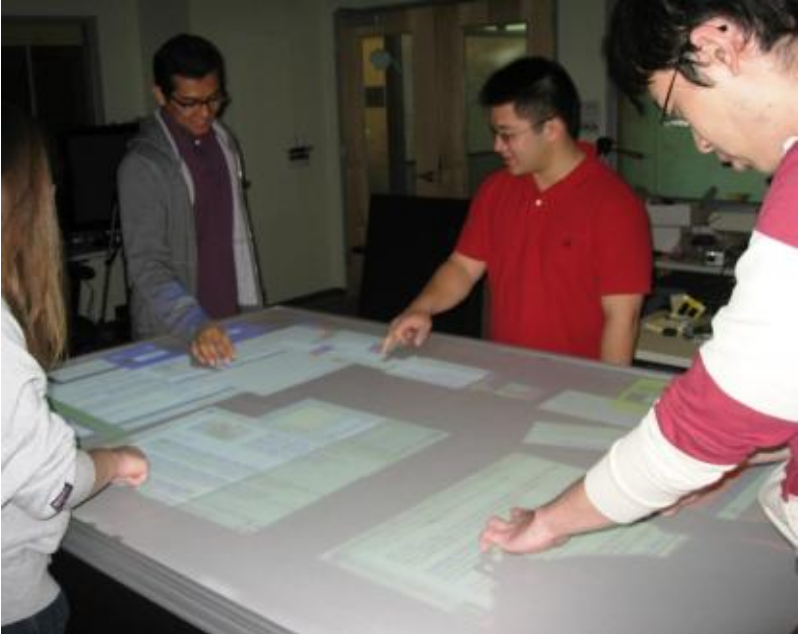 a group of people standing around a table