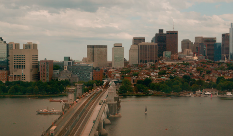 a long bridge over a body of water with a city in the background