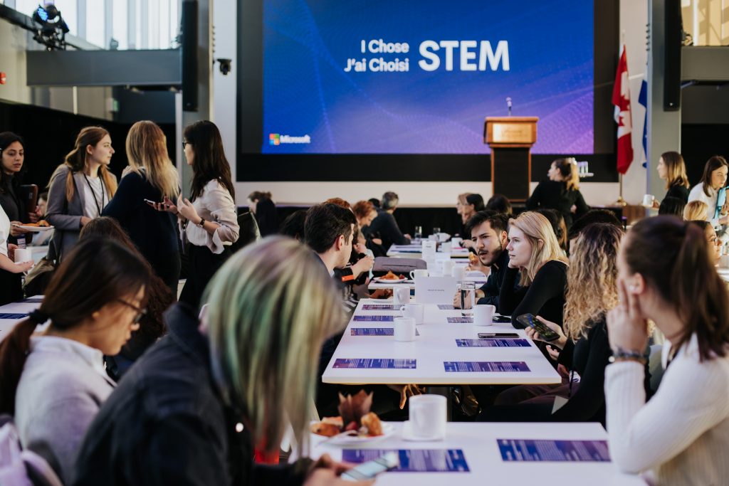 a group of people sitting at a table in front of a crowd