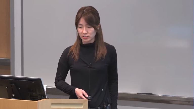 a woman standing in front of a laptop