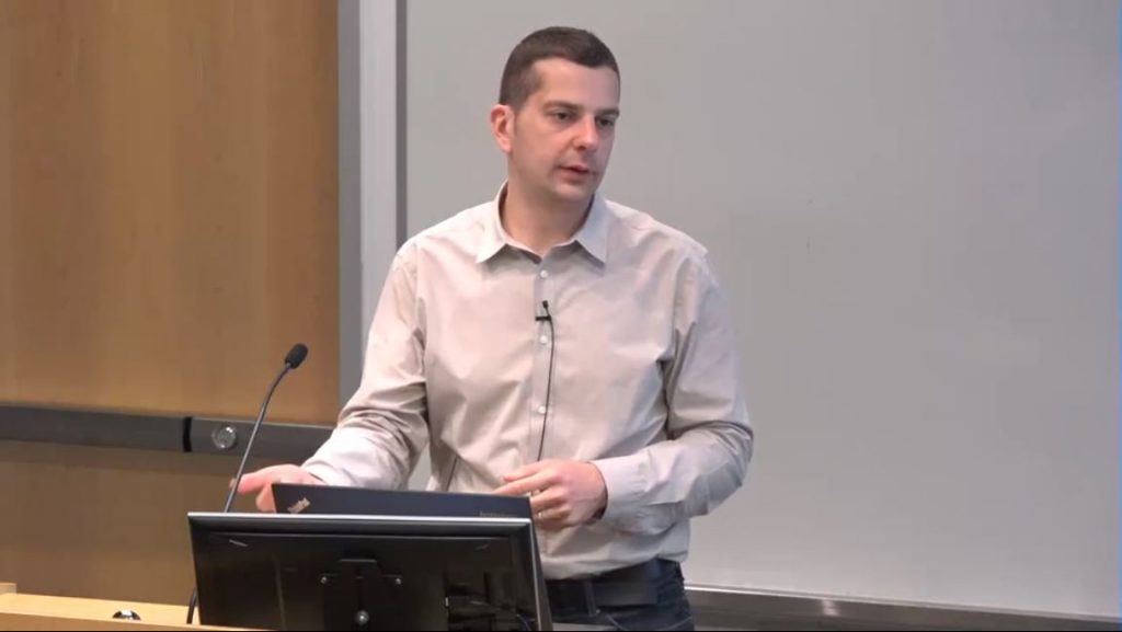 a man standing in front of a laptop