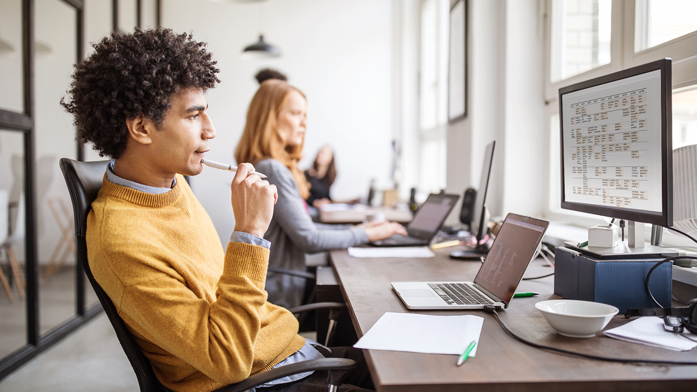 a person sitting at a table using a laptop