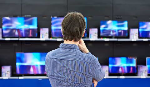 Person looking at televisions for sale in a department store.