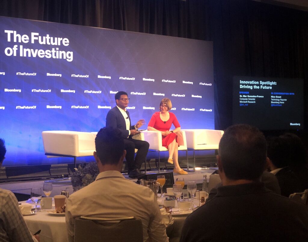a group of people sitting at a table in front of a computer screen
