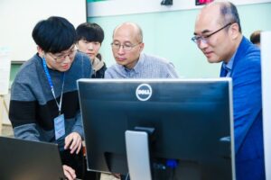 a group of people looking at a laptop