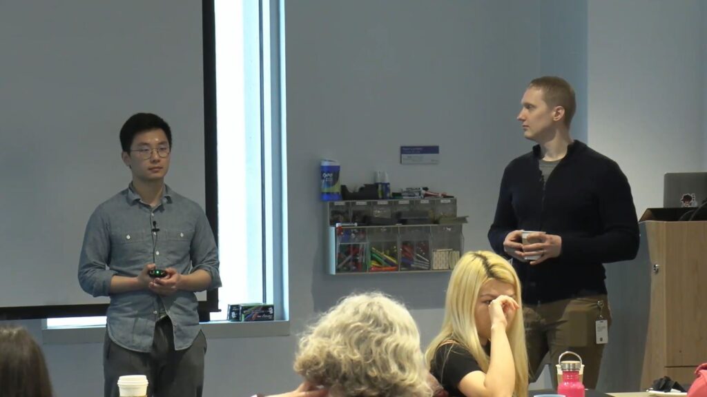 a person standing in front of a group of people in a room