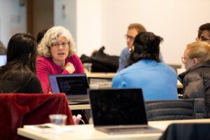 Kristin Lauter et al. sitting at a table using a laptop