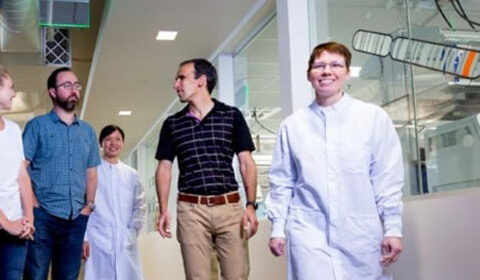 Group of men and women walking down a lab hallway