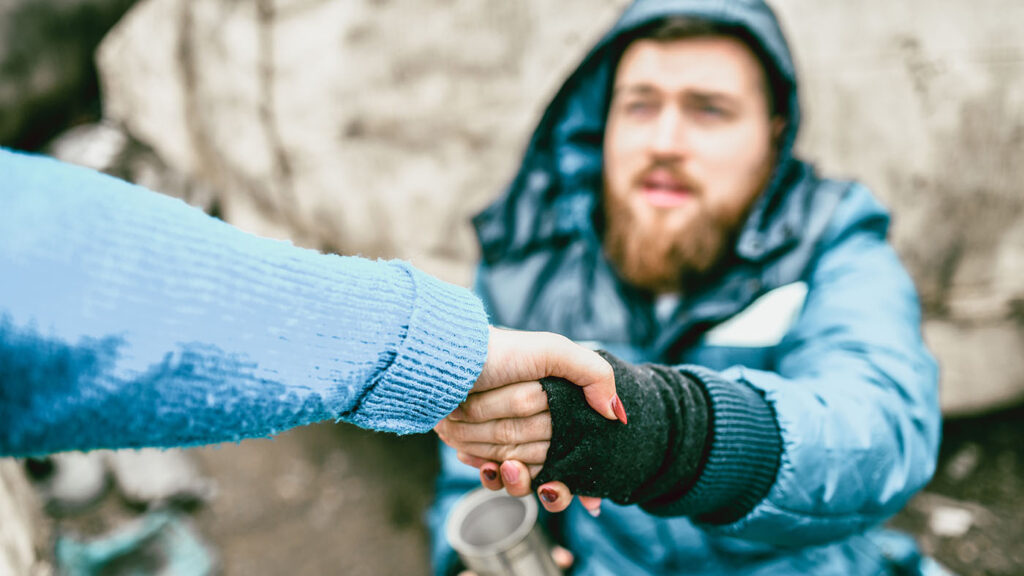 societal individual resilience image: Homeless Male On The Street Getting Help From Female