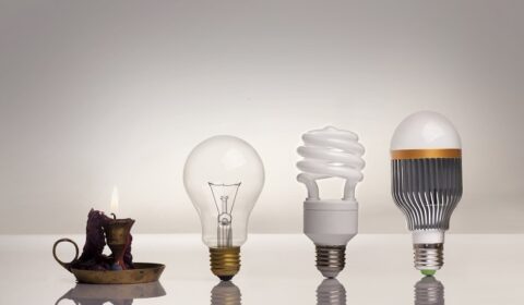 evolution of lighting, with candle, tungsten, fluorescent and LED bulb