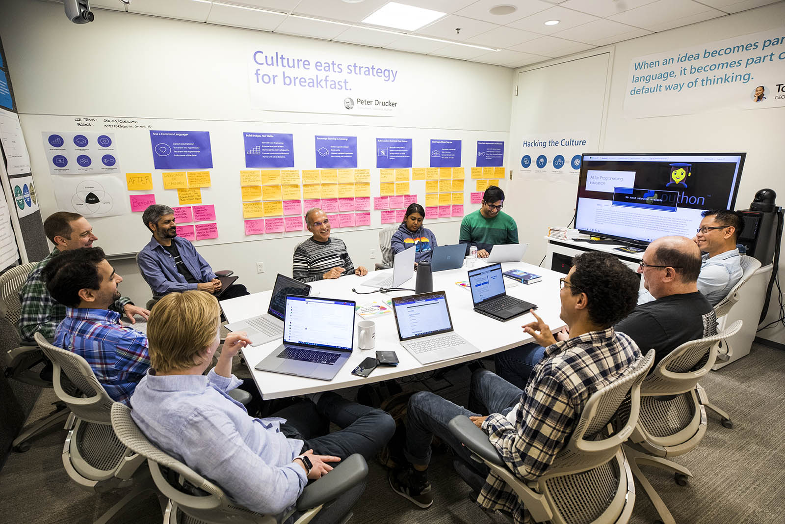 a group of people sitting at a desk with a laptop computer