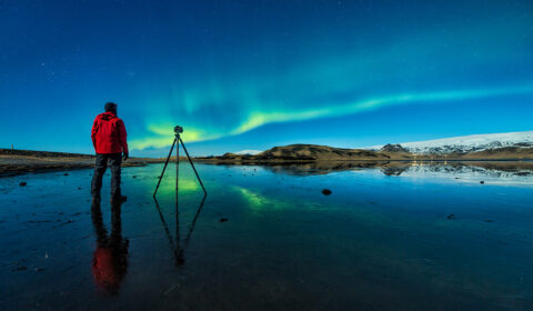 climate research - photo of a man taking a photo of the Northern Lights