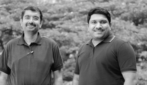 a couple of people that are standing in the grass