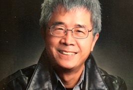 a man wearing glasses and smiling at the camera