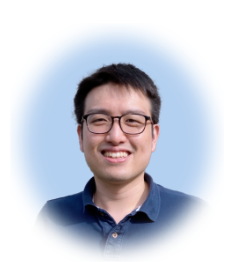 a man wearing glasses and smiling at the camera