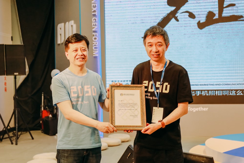 微软亚洲研究院院长洪小文向微软亚洲研究院院友王坚颁发首个院友会奖学金设立证书,王坚也是微软亚洲研究院首位“终身馒头”