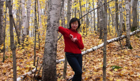 a person standing next to a tree in a forest