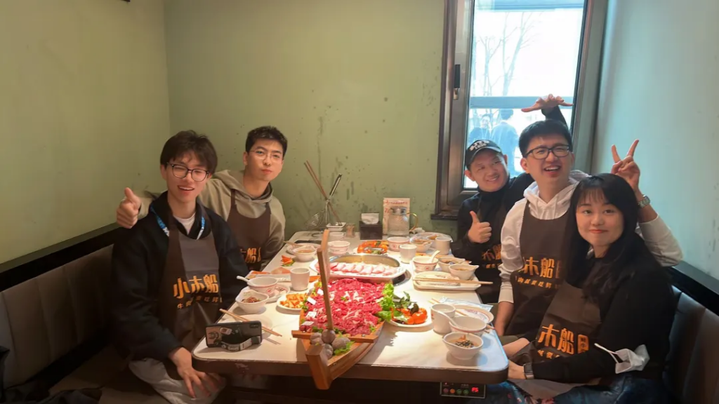 a group of people sitting at a table with food