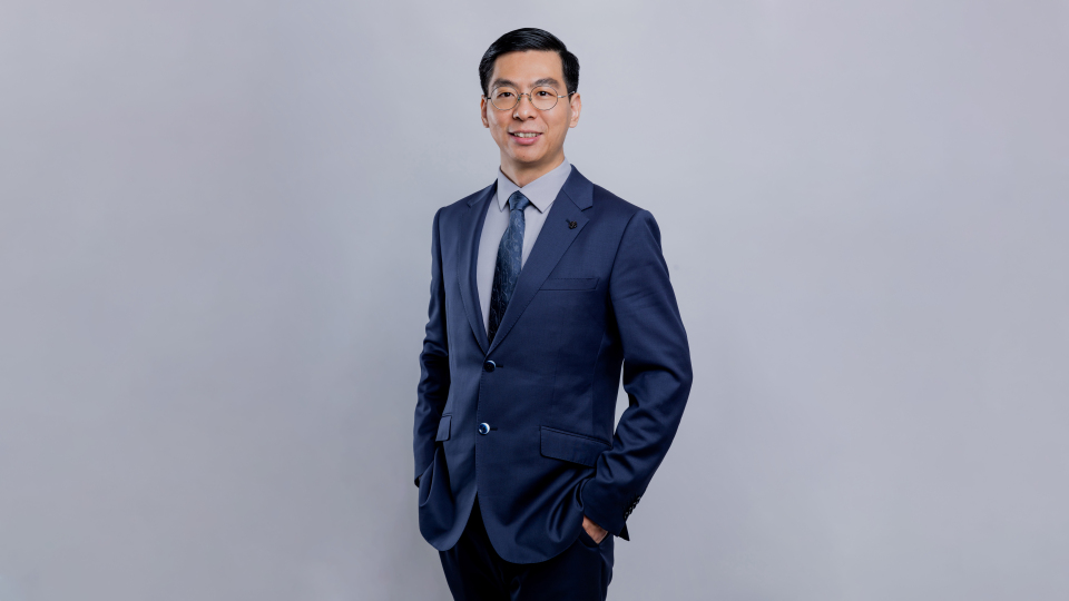 photo of Xinxing Xu standing against a gray background