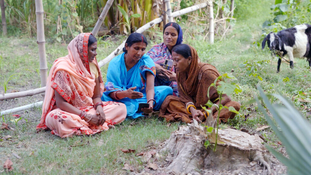 In Bihar, India, Lakshmi Devi (center) and fellow farmers use the FarmerChat app to watch videos in their local language that share best practices for managing crops and livestock.