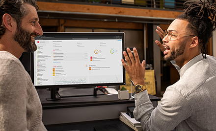 Image of two men in front of a computer monitor.