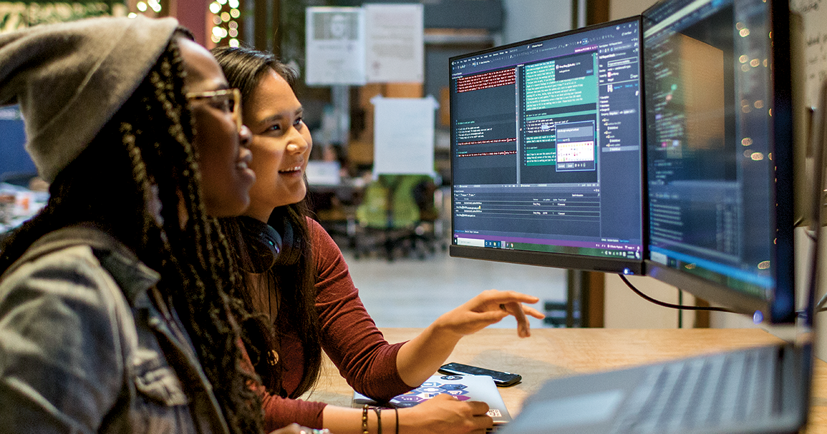 Two female developers working and collaborating in an enterprise office.