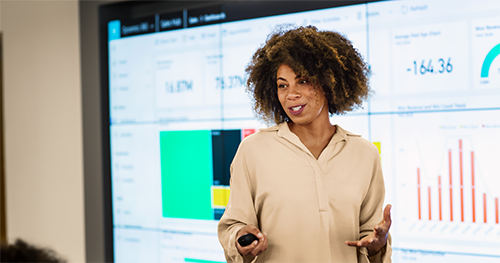 CFO presenting sales results to large group meeting.