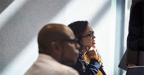 An image of a female and male enterprise employees collaborating in a conference room.