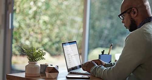 Male working remotely from his home office on a Dell Latitude 13 device, running Microsoft Word.