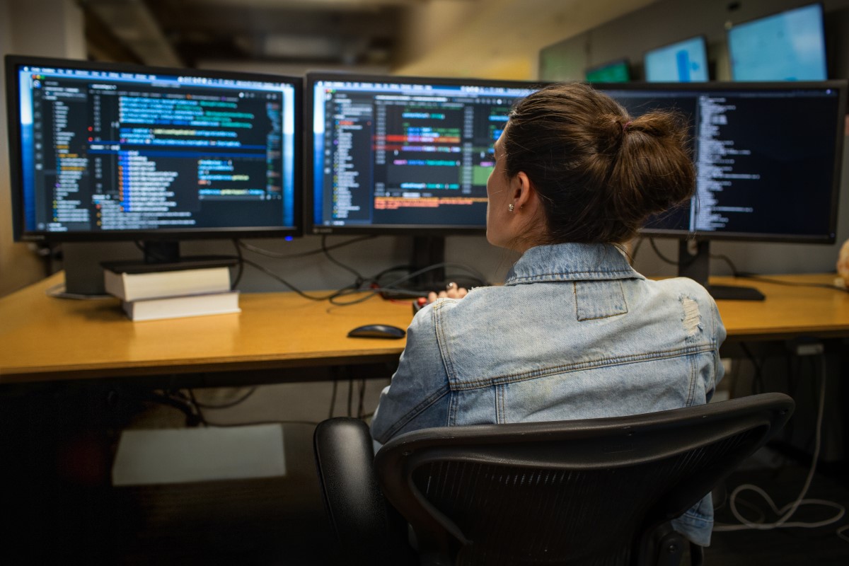 Female developer coding her workspace in an office.