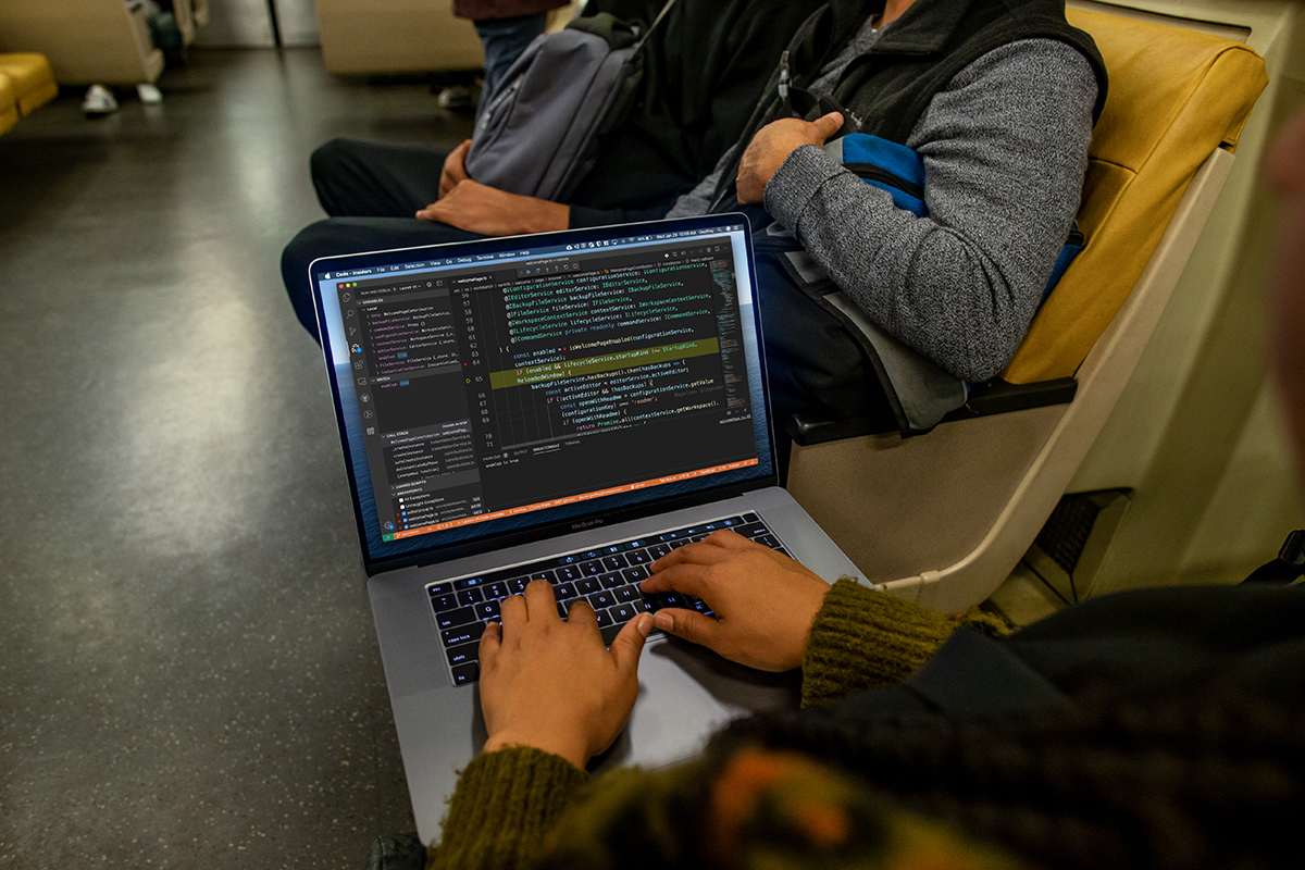 Image of a person working on a MacBook Pro in the subway