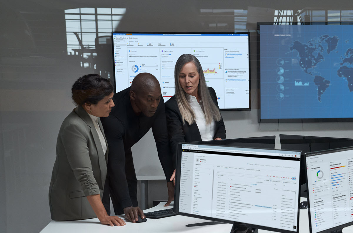 a group of people sitting at a desk in front of a computer
