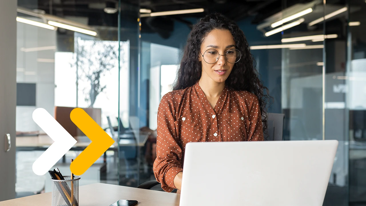 A woman sitting at a table using a laptop.