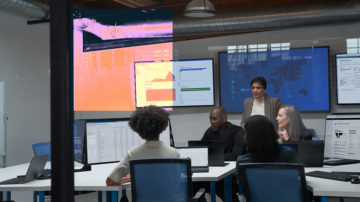 A group of people sitting around a table with computers.