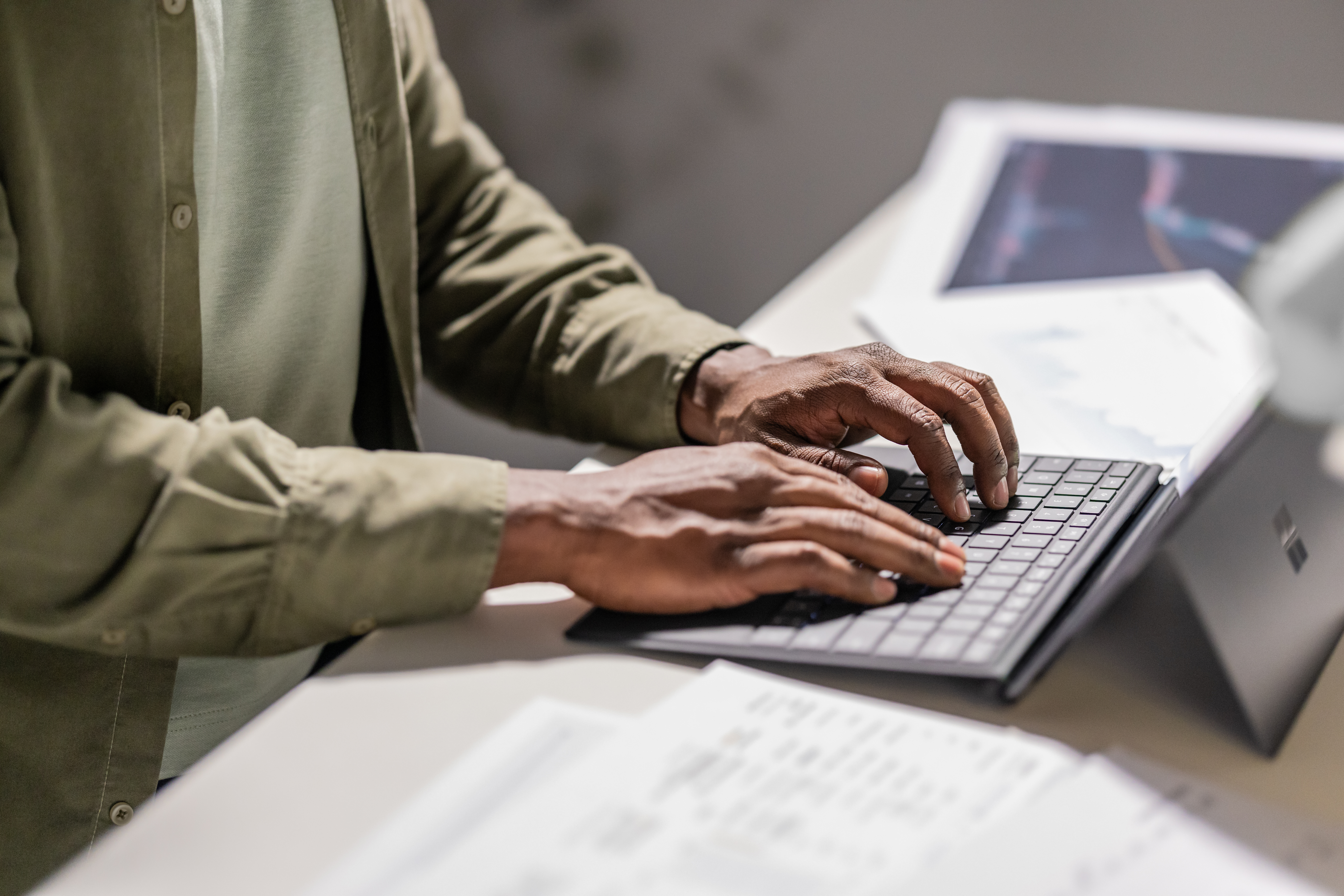 Close up of hands typing on keyboard of Surface tablet.