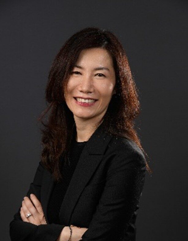 Headshot of women smiling in black shirt with arms crossed