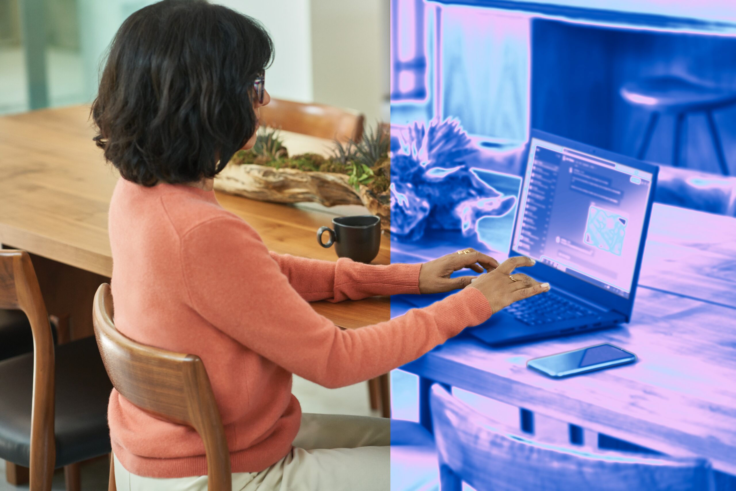 Woman sitting at desk typing on laptop