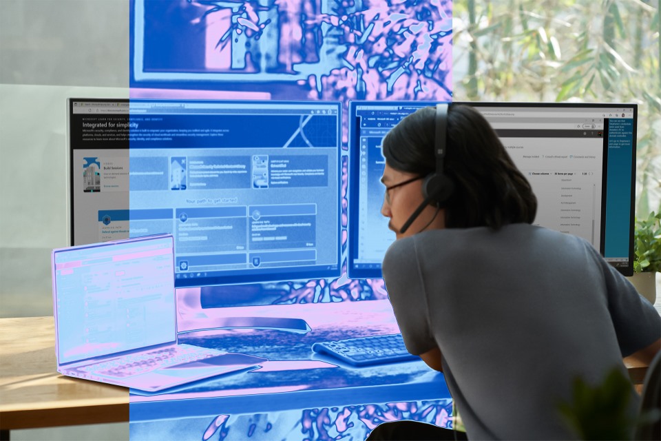 A security practitioner sits at a computer.