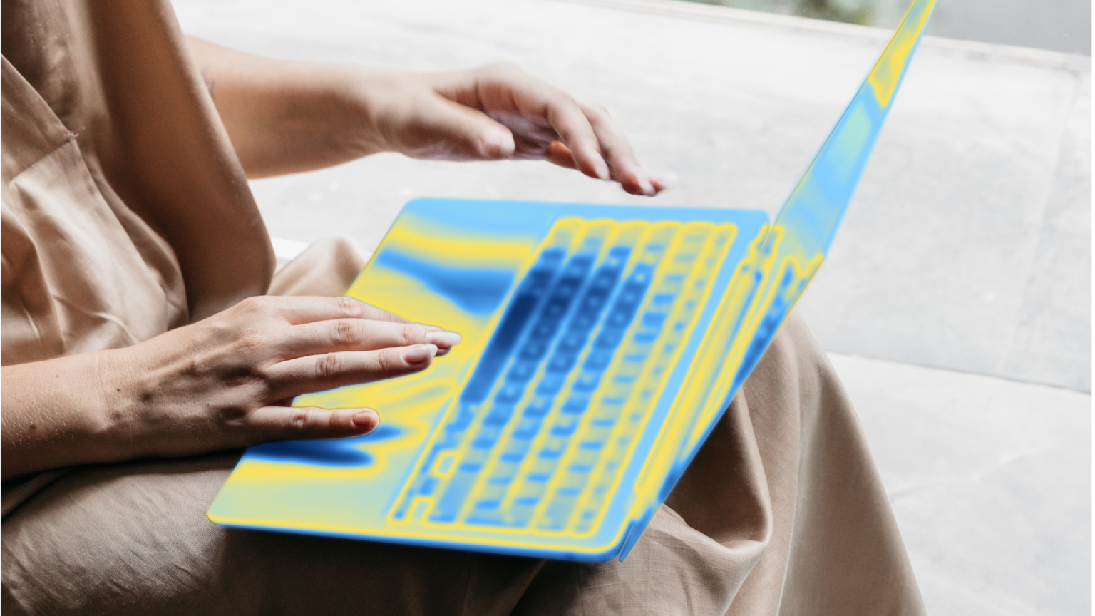Woman typing on laptop blue and green device