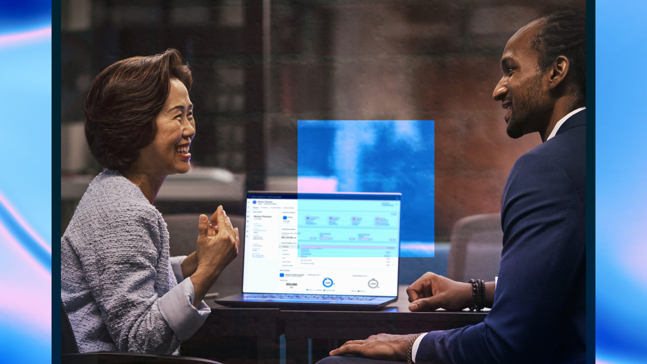 Satisfied customer working with investment advisor on investment decisions with monitor showing intelligent app powered by Azure to make intelligent, real-time decisions with customers.