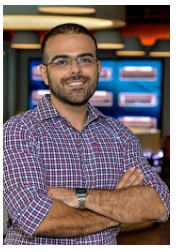 a man standing in front of a laptop