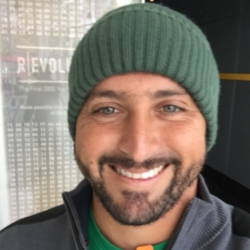 a man wearing a hat and smiling at the camera