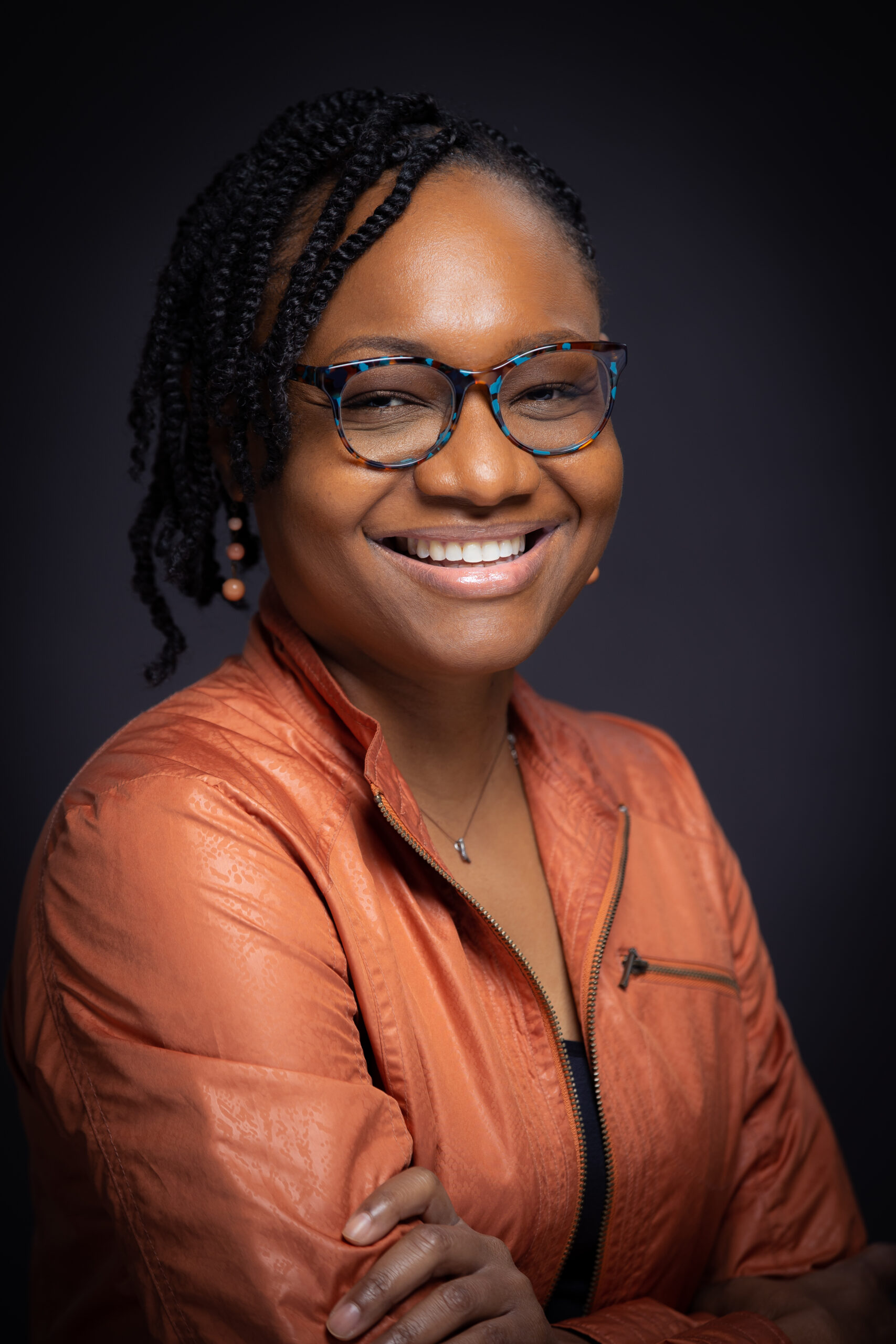 a person wearing glasses and smiling at the camera