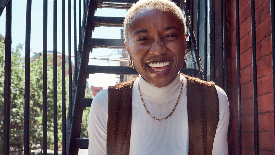 A smiling woman sitting on an exterior staircase