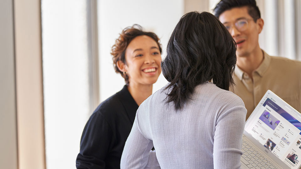 Coworkers have a conversation around a laptop