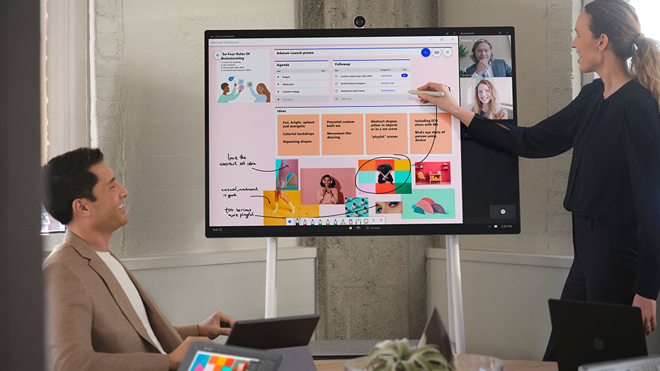 A woman draws over data on an interactive monitor with a stylus