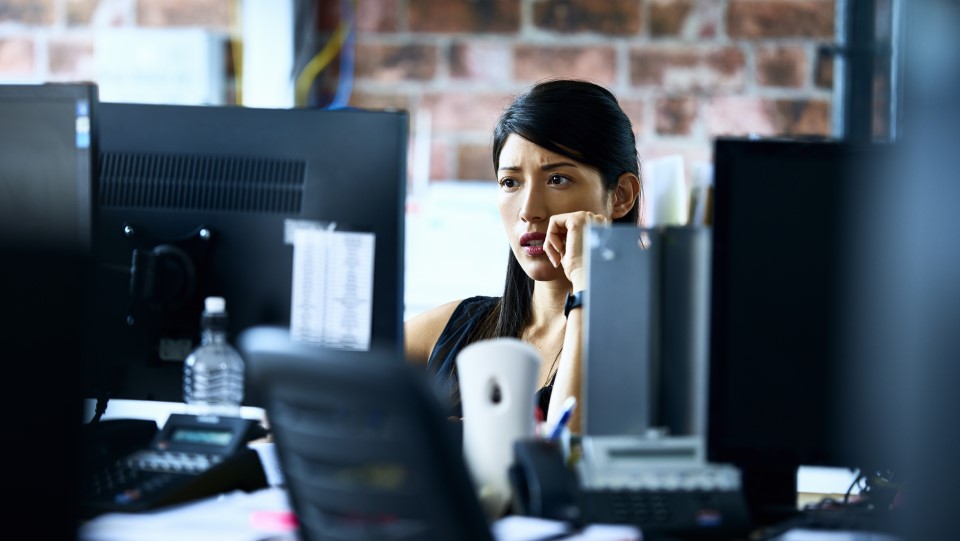 A woman stares worriedly at her compurer.